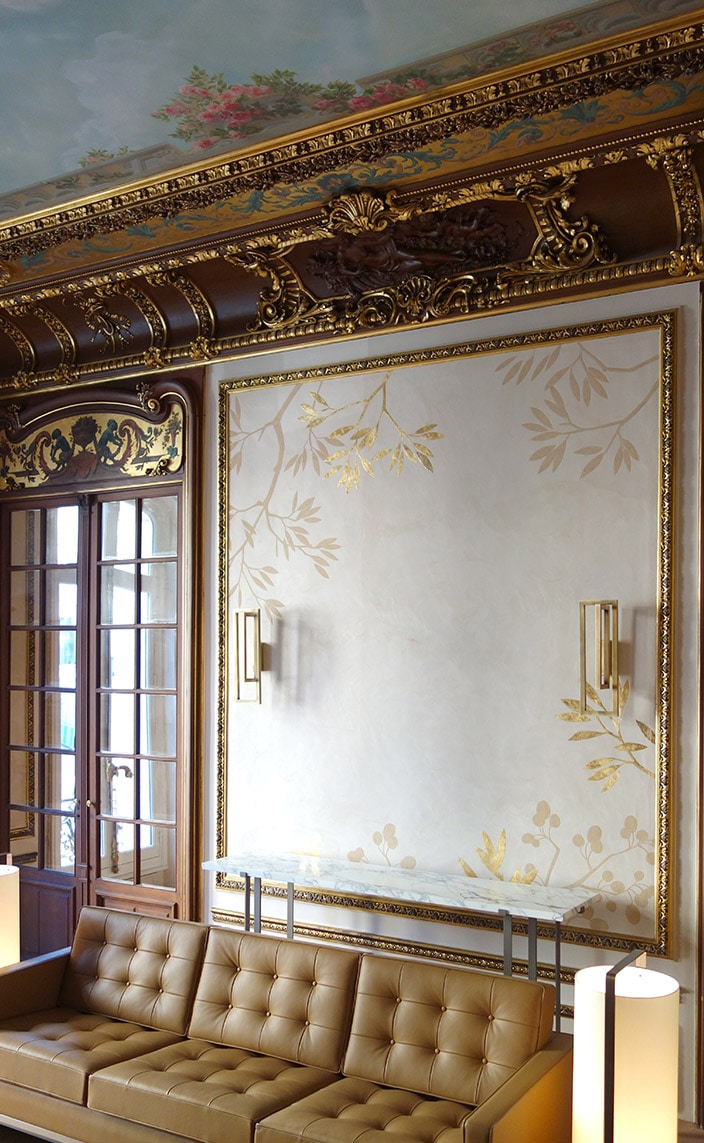 Solène Eloy - Fresquiste - Atelier du Mur - Décors muraux - Fresque motif feuillage doré - Canapé en cuir capitonné - Signatures Singulières Magazine